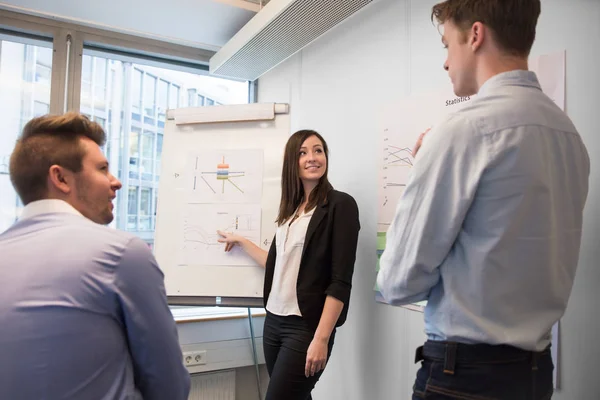 Smiling Female Professional Explaining Chart To Colleagues — Stock Photo, Image