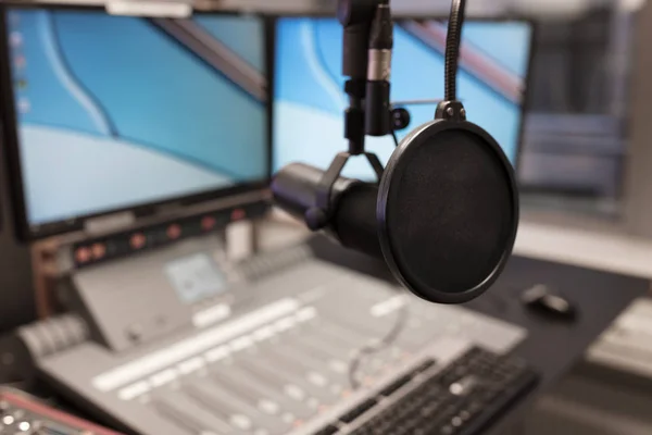 Bildskärmar och mikrofon över bordet i radiostudio — Stockfoto