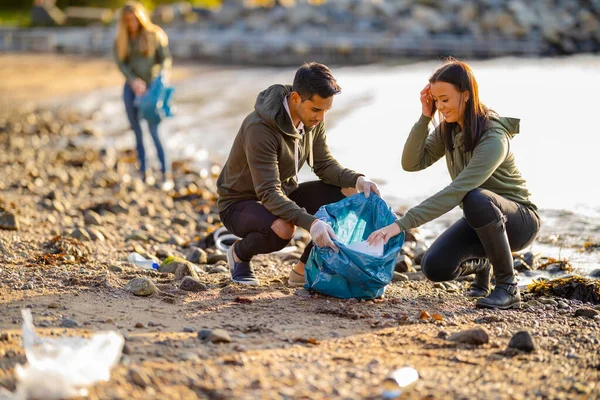 Equipo de voluntarios recogiendo basura en la playa — Foto de Stock