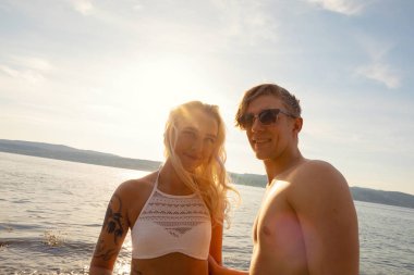 Sahilde gülümseyen güzel bir genç adam ve kadının portresi