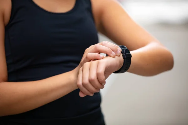 Primer plano de la mujer que utiliza el dispositivo de reloj inteligente fitness después de correr —  Fotos de Stock
