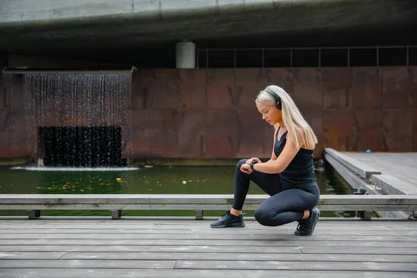 Corredor hermosa mujer fitness usando el teléfono reloj inteligente —  Fotos de Stock