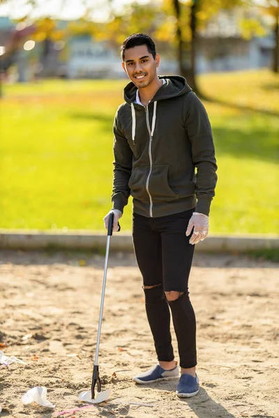 Confident volunteer cleaning park on sunny day — Stock Photo, Image