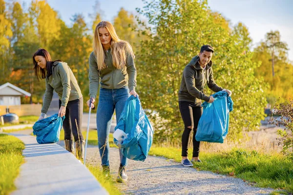Genç gönüllüler parkta çöp topluyor.