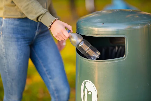 Midsection of woman putting bottle in garbage bin — Stock Photo, Image