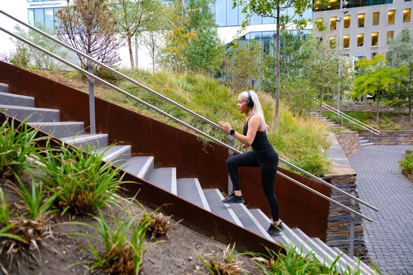 都市公園の階段でハードインターバルワークアウトを行うスポーツ女性をフィット — ストック写真