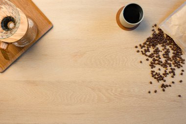 Kavrulmuş fasulye ve sıcak kahve fincanlı el yapımı bira makinesi.