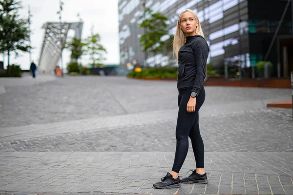 Hermosa mujer escandinava urbana en traje de entrenamiento de pie en la ciudad — Foto de Stock