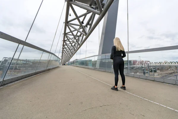 Corredor de fitness mujer de pie en el puente en la ciudad de aspecto moderno —  Fotos de Stock