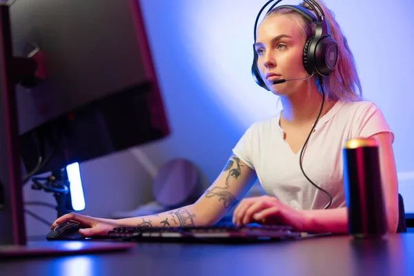 Professionell gamer flicka med headset spela online multiplayer videospel på PC — Stockfoto