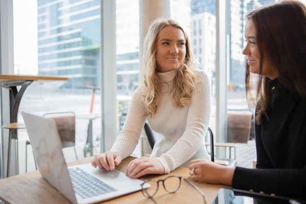 Şehirdeki modern kahve dükkanında okul projesi üzerinde çalışan kız öğrenciler.