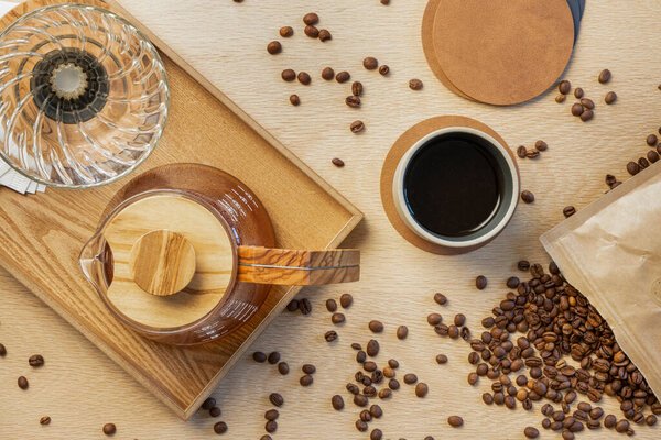 Directly above shot of fresh coffee with roasted beans on wooden table