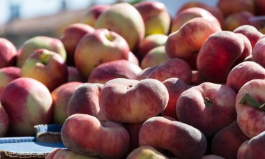 incir şeftali. Saturn şeftali. düz şeftali hasat. birçok şeftali. Çiftçi pazarında taze meyve: şeftali. incir şeftali arka plan