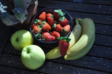 Sepette çilek var. Masada çilekler var. Bahçede yaz çilekleri.