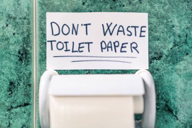 Tuvalet kağıdını israf etme. Coronavirus için tuvalet kağıdı rulosunun üstündeki mesaj..