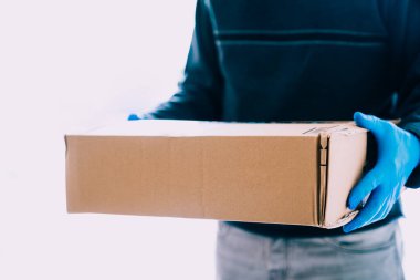 Koronavirüs için güvenlik önlemi olarak mavi lateks eldivenli paket teslimatçısı. Kurtarıcılar kopya uzayı ile karantina zamanında.