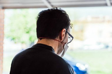 Koronavirüsten korunmak için maskeyle yürüyüşe çıkan biri. Adam karantina sırasında alışverişe çıkıyor..