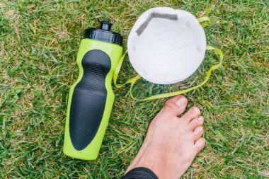 Koronavirüsün yayılmasını önlemek için gerekli önleyici önlemlerle dışarıda yoga pratiği yapıyorum. Parkın yeşil çimlerinde zihinsel olarak rahatlatıcı ve kopuk bir insan..