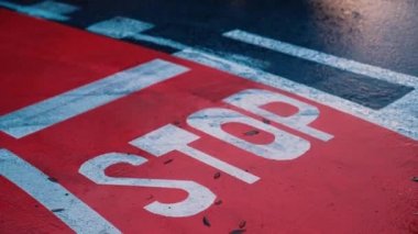 Yağmurlu bir günde kırmızı asfalt bir bisiklet yolunda dur işareti.