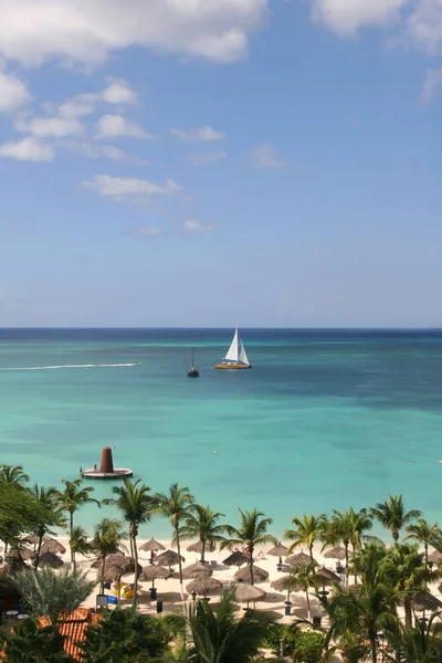 View of beautiful tropical beach with a sailboat in the background. — 스톡 사진