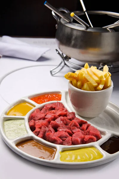 Meat fondue with different sauces and french fries. — Stock Photo, Image