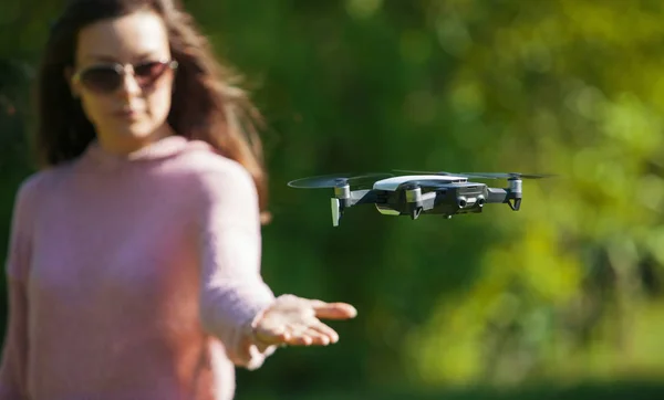 Camina con un dron. Mujer joven con gafas negras lanza un dron de vuelo bajo. Llega a los aviones no tripulados de vuelo bajo, capturas . —  Fotos de Stock