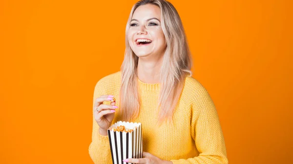 Νεαρή χαρούμενη γυναίκα που βλέπει μια ταινία και τρώει ποπ κορν. — Φωτογραφία Αρχείου