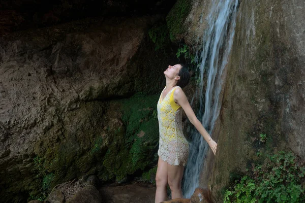 Fille lave son visage sous la cascade dans les bois. Jeune femme en maillot de bain en rivière de montagne — Photo