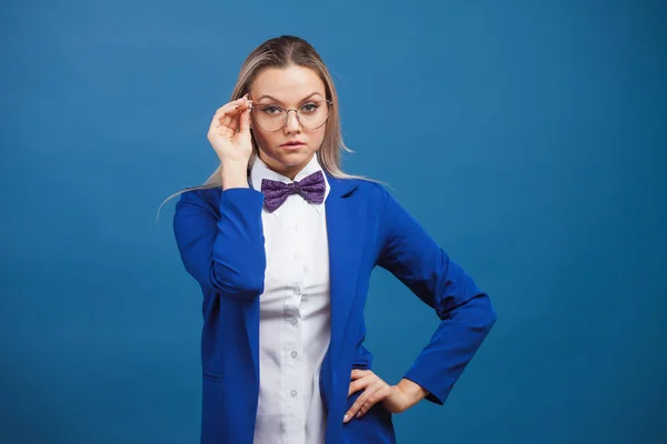 Mujer de negocios en una elegante chaqueta azul y pajarita ajusta sus gafas . — Foto de Stock