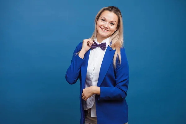 Vtipná obchodní dáma v modrém saku a fialovém motýlku. Studio portrét na modrém pozadí — Stock fotografie
