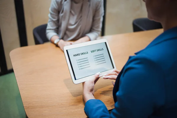 Job interview. The recruiter holds a tablet with a check list of the necessary skills of the candidate.