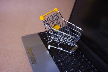 Şimdi satın al, internetten alışveriş manyağı. Çevrimiçi alışveriş, dizüstü bilgisayarda alışveriş arabası.