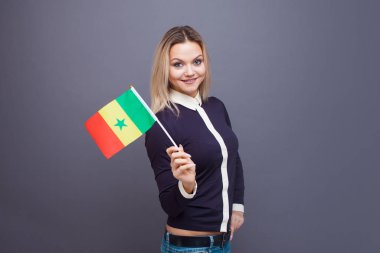 Göçmenlik ve yabancı dil eğitimi, konsept. Elinde Senegal bayrağı olan gülümseyen genç bir kadın.