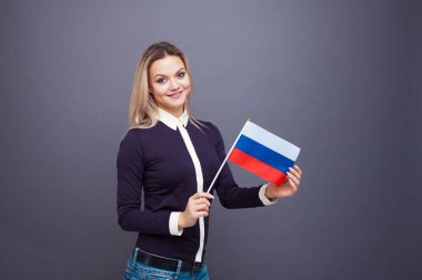 Göçmenlik ve yabancı dil eğitimi, konsept. Elinde Rusya bayrağı olan gülümseyen genç bir kadın..