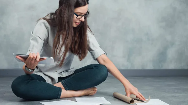 Jonge vrouwelijke freelancer en ondernemer werkt aan een project op de vloer. — Stockfoto