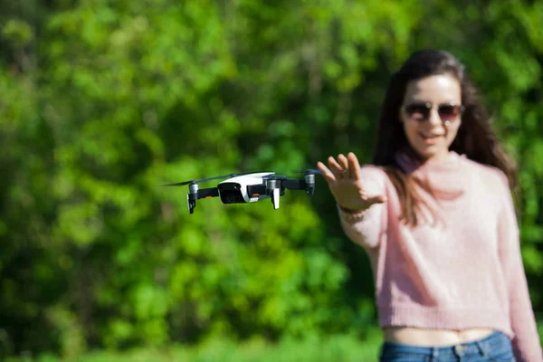 Camina con un dron. Mujer joven con gafas negras lanza un dron de vuelo bajo. Llega a los aviones no tripulados de vuelo bajo, capturas . —  Fotos de Stock