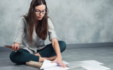 İç mimar geleceği planlıyor. Boş bir dairede yerde oturuyor..