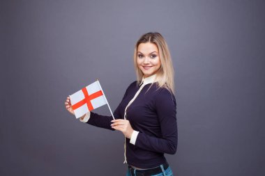 Göçmenlik ve yabancı dil eğitimi, konsept. Elinde İngiltere bayrağı olan gülümseyen genç bir kadın..