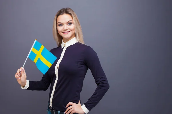 Inmigración y el estudio de lenguas extranjeras, concepto. Una joven sonriente con una bandera de Suecia en la mano. — Foto de Stock