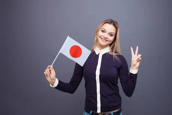 이민 과 외국어 공부, 개념. 손에 일본 국기를 들고 미소를 짓고 있는 젊은 여자. — 스톡 사진