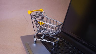 Şimdi satın al, internetten alışveriş manyağı. Çevrimiçi alışveriş, dizüstü bilgisayarda alışveriş arabası.