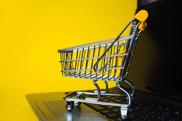 End of online sales. Online shopping, shopping cart on laptop keyboard.