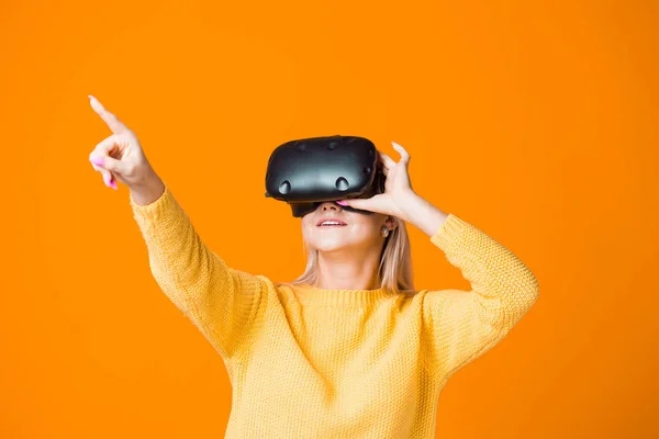 Jogador de jogos de computador usa realidade virtual. Uma jovem mulher em um capacete realidade virtual — Fotografia de Stock