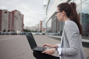 Kariyer gelişimi ve hırs, konsept. Dizüstü bilgisayarı olan genç bir iş kadını.