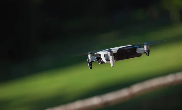 Drone a quattro eliche che vola in natura contro la natura verde La manovra. Sfondo sfocato . — Foto Stock