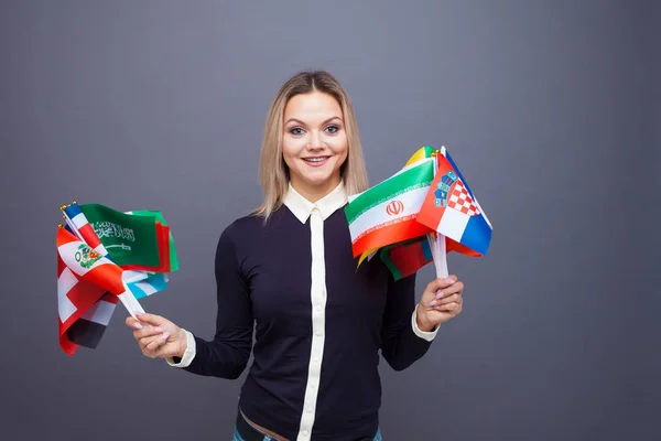 Joven alegre con un gran conjunto de banderas de diferentes países del mundo — Foto de Stock