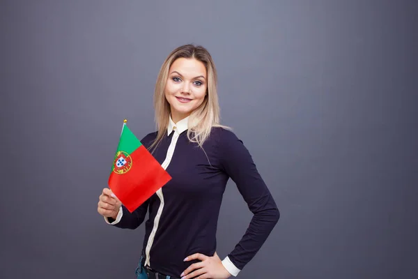 Invandring och studier av främmande språk, begrepp. En ung leende kvinna med en portugisisk flagga i handen. — Stockfoto