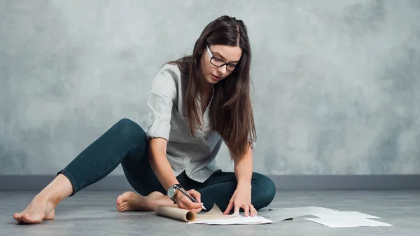 Jonge vrouwelijke freelancer en ondernemer werkt aan een project op de vloer. — Stockfoto