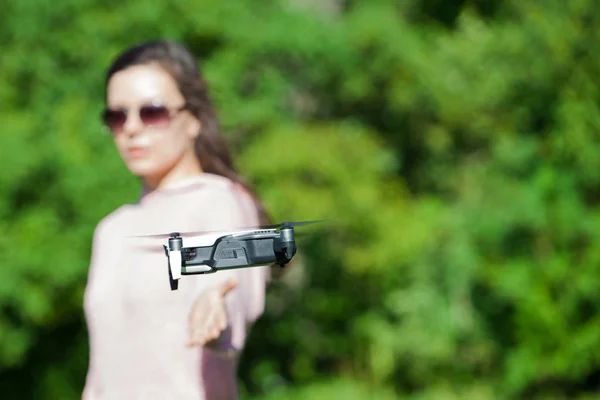 Camina con un dron. Mujer joven con gafas negras lanza un dron de vuelo bajo. Llega a los aviones no tripulados de vuelo bajo, capturas . —  Fotos de Stock