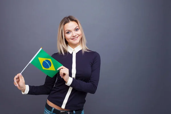 Immigration and the study of foreign languages, concept. A young smiling woman with a Brazil flag in her hand.